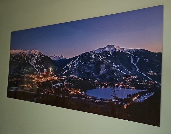 Photo de l’œuvre volée montrant des montagnes enneigées et des pistes de ski au crépuscule