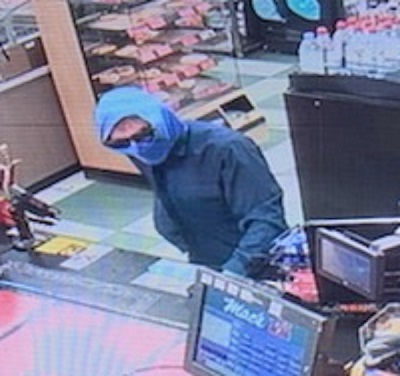 Photo of suspect male wearing sunglasses, a blue head and face covering and a blue jacket