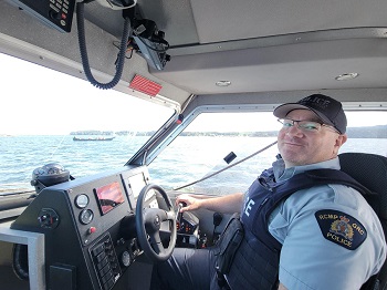 1)&#9;Photo du gendarme Harrison dirigeant le bateau de police de Port Hardy pour escorter le voyage en canot.