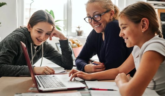 Mother and 2 daughters looking at computer screen