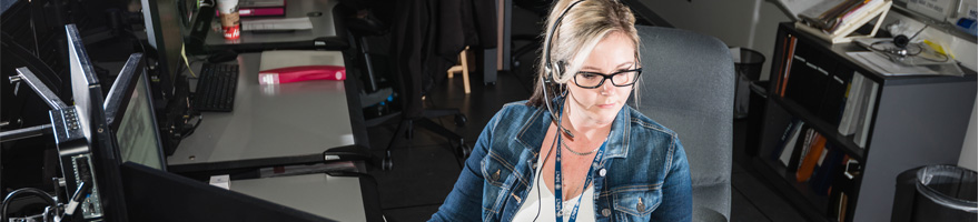 9-1-1 dispatcher sitting in front of several computer screens