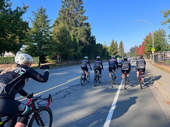 : À vélo, la gendarme Page prend une photo de cinq membres de son équipe qui roulent devant elle.