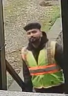 South Asian male dressed as delivery driver wearing a high visibility vest.
